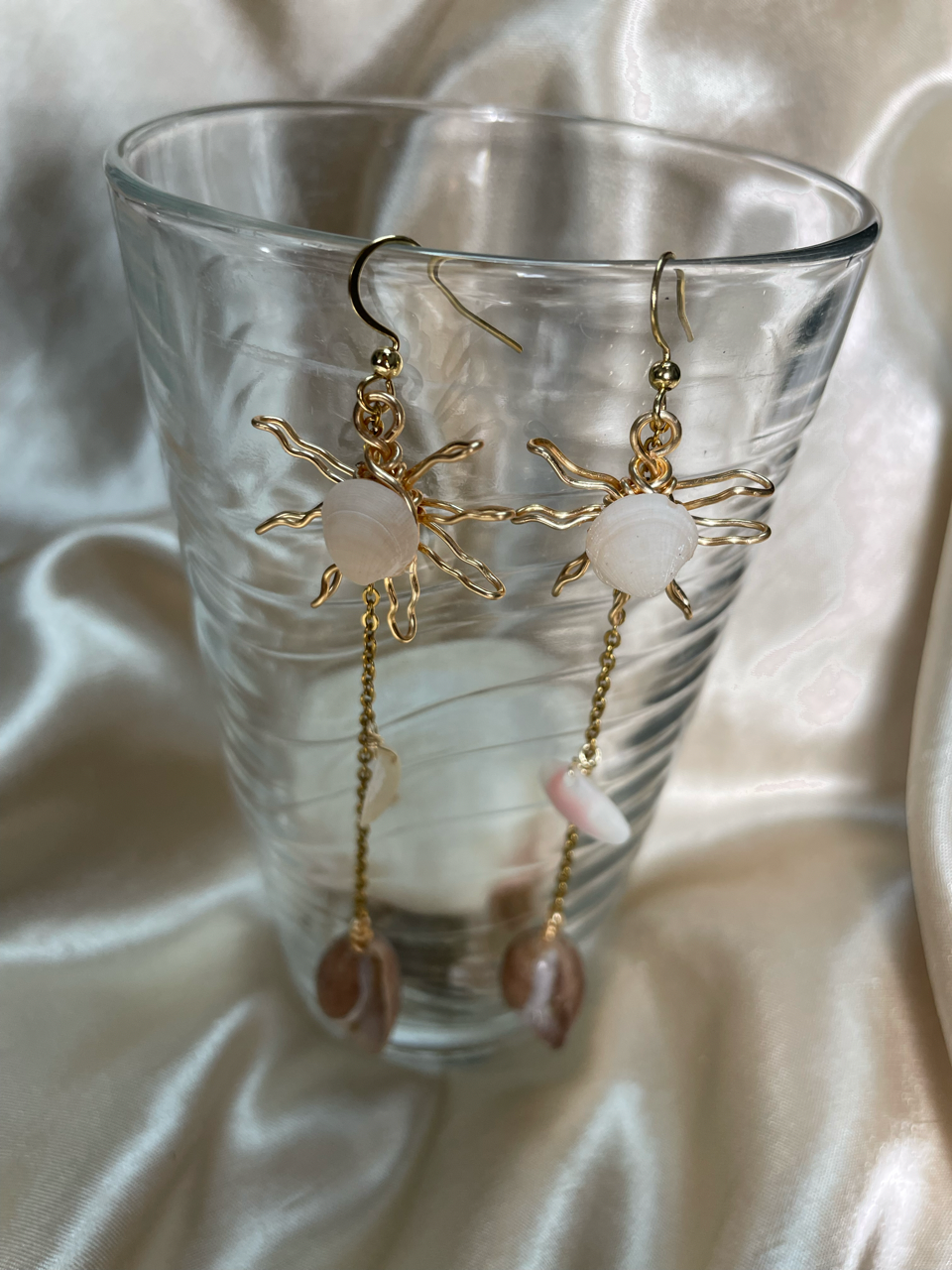 Aretes artesanales dorados con concha natural en forma de sol