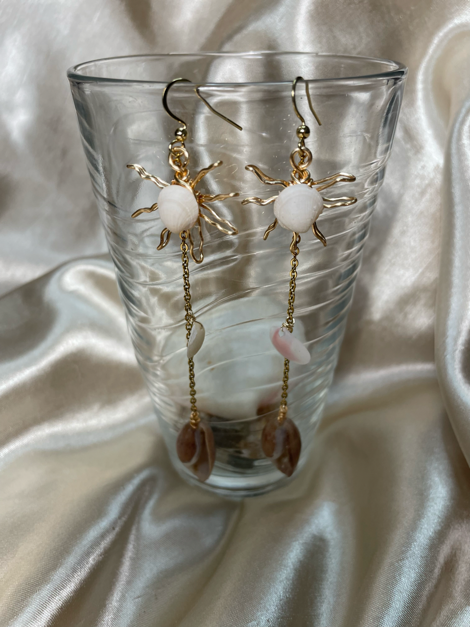 Aretes artesanales dorados con concha natural en forma de sol
