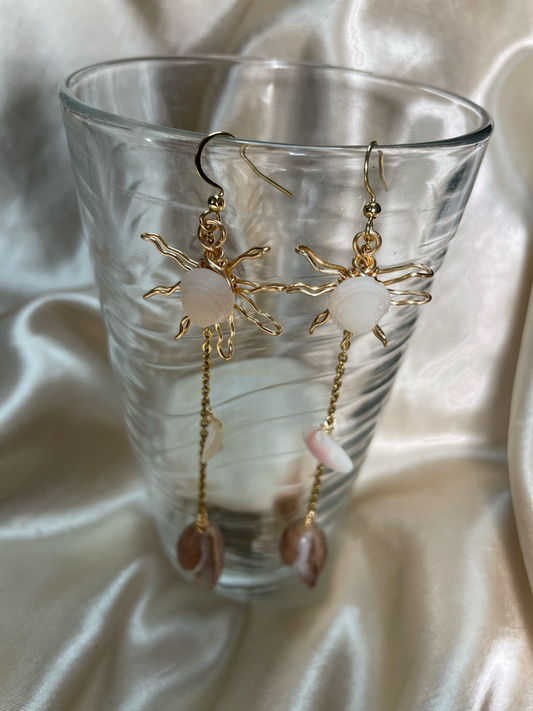 Aretes artesanales dorados con concha natural en forma de sol