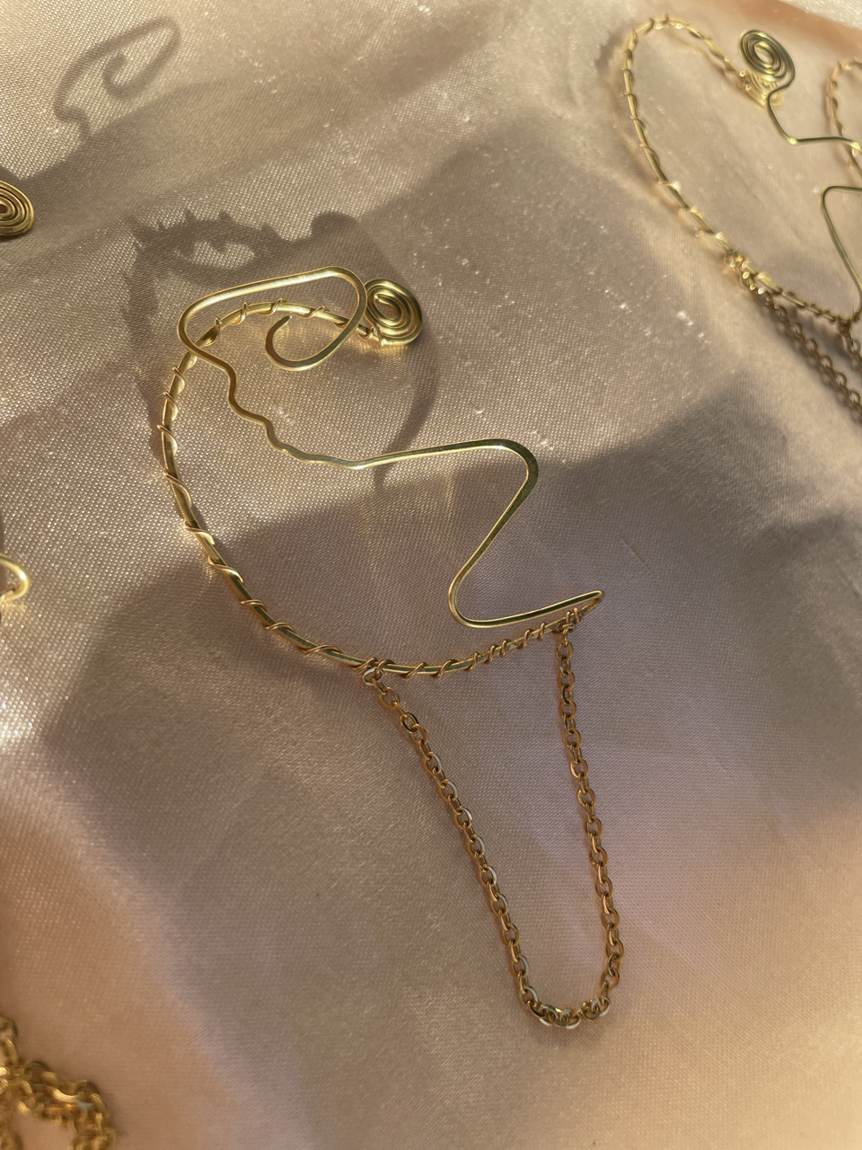 Earcuff abstracto en dorado con cadena decorativa